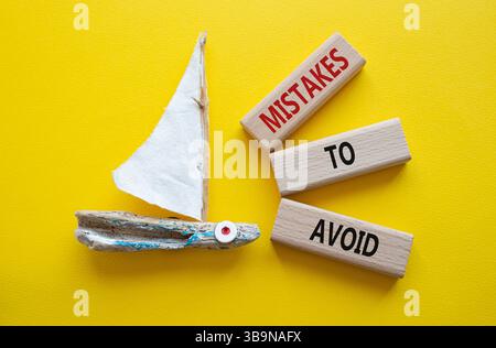 Fehler, um Symbol zu vermeiden. Holzblöcke mit Wortfehlern, die man vermeiden sollte. Schöner gelber Hintergrund mit Boot. Geschäfte und Fehler zur Vermeidung von Konzepten. C Stockfoto
