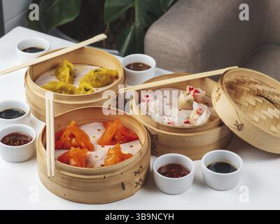 Dim Sum Geschirrset. Traditionelles Asan-Brunch. Gedämpfte Knödelgerichte mit Sojasauce auf dem Hintergrund des Restauranttisches. Dim Sum traditionelles Chinesisch und Stockfoto