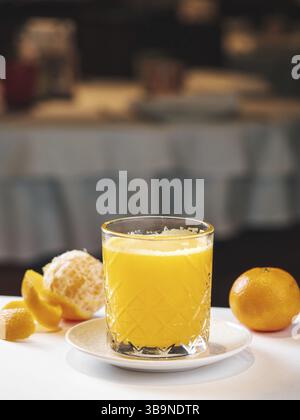 Frischer Mandarinensaft im Restaurant. Gelber Mandarinenshake zum Drink. Erfrischendes Getränk an heißen Tagen. Süßer Mandarinensaft im Glas. Glas Stockfoto