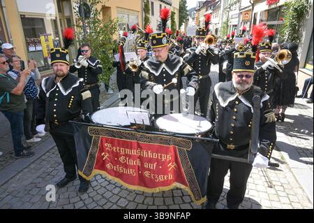 Sangerhausen, Deutschland. Mai 2025. Das Bergbaumusikkorps „Glück auf“ aus Oelsnitz nimmt an der Bergbauparade 2025 Teil. Im Hintergrund sehen Sie den Verderb-Tipp auf der „Hohen Linde“. Die Parade ist der Höhepunkt des Jubiläumsjahres „825 Jahre Kupferschieferabbau im Bergbaugebiet Sangerhausen und der Mansfeld Mulde“. Der Bergbau hat die Landschaft und die Menschen in der Region geprägt und ist bis heute sichtbar. Quelle: Heiko Rebsch/dpa/Alamy Live News Stockfoto