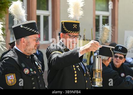 Sangerhausen, Deutschland. Mai 2025. Zwei Bergleute, die an der Bergbauparade 2025 teilnahmen, haben eine Bergarbeiterlampe angezündet. Die Parade ist der Höhepunkt des Jubiläumsjahres „825 Jahre Kupferschieferabbau im Bergbaugebiet Sangerhausen und der Mansfeld Mulde“. Der Bergbau hat die Landschaft und die Menschen in der Region geprägt und ist bis heute sichtbar. Quelle: Heiko Rebsch/dpa/Alamy Live News Stockfoto