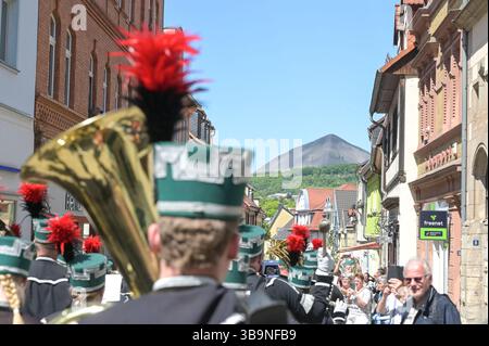 Sangerhausen, Deutschland. Mai 2025. Die Bergwerke-, Hütten- und Bergbauverbände nehmen an der Bergbauparade 2025 Teil. Im Hintergrund ist die Spoil-Spitze auf der „Hohen Linde“ zu sehen. Die Parade ist der Höhepunkt des Jubiläumsjahres „825 Jahre Kupferschieferabbau im Bergbaugebiet Sangerhausen und der Mansfeld Mulde“. Der Bergbau hat die Landschaft und die Menschen in der Region geprägt und ist bis heute sichtbar. Quelle: Heiko Rebsch/dpa/Alamy Live News Stockfoto