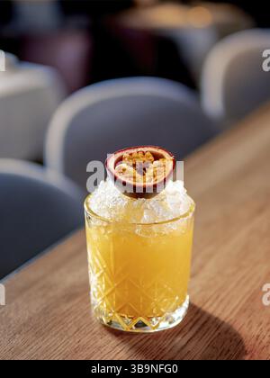Gelber, altmodischer erfrischender Cocktail mit Whiskey und Crushed Ice an der Bar. Vertikal. Alkohol oder alkoholfreier kalter Cocktail dekoriert Leidenschaft Stockfoto