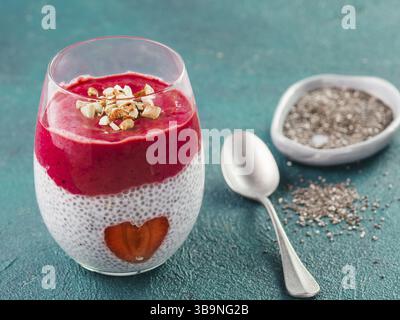 Idee für gesundes Frühstück am Valentinstag: Chia Pudding mit roten Beeren Püree, gehackte Mandeln auf und Erdbeere in der Form des Herzens. Kopieren Sie sp Stockfoto