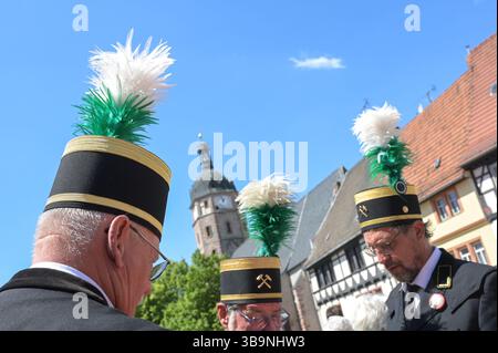 Sangerhausen, Deutschland. Mai 2025. Bergleute mit ihren Bergmannshüten stehen vor der Jakobi-Kirche, dem Ausgangspunkt der Bergbauparade von 2025. Die Parade ist der Höhepunkt der „825 Jahre Kupferschieferabbau im Bergbaugebiet Sangerhausen und der Mansfeld Mulde“. Der Bergbau hat die Landschaft und die Menschen in der Region geprägt und ist bis heute sichtbar. Quelle: Heiko Rebsch/dpa/Alamy Live News Stockfoto