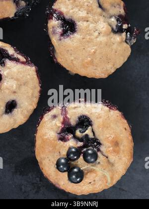 Muffins mit Schwarze Johannisbeere auf dunklem Hintergrund. Top View oder flach Stockfoto