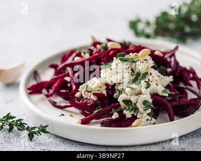 Roher Rote Bete Spaghetti Salat mit Weichkäse, Nüssen, Thymian. Gemüsennudeln - frische Rote Bete Nudeln mit Ricotta und frischem Thymian auf dem Teller. Spa kopieren Stockfoto