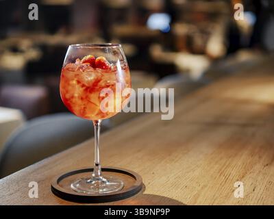 Transparenter rosafarbener Alkoholcocktail im Weinglas mit Eis, aperol und Gin an der Bar im Restaurant. Alkohol trinken Aperol Spritz Aperitif c Stockfoto
