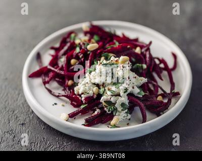 Roher Rote Bete Spaghetti Salat mit Weichkäse, Nüssen, Thymian. Gemüsennudeln - frische Rote Bete Nudeln mit Ricotta und frischem Thymian auf dem Teller. Spa kopieren Stockfoto