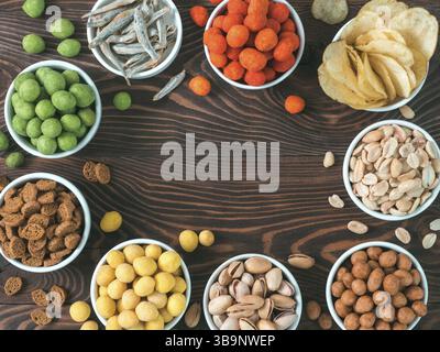 Sortiment von verschiedenen Snack für Bier, Wein, Party. Erdnüsse in Coconut Glasur, grüne vasabi, rote scharfe Chili, gelben Käse Glasur, Chips, Pistazie, Stockfoto