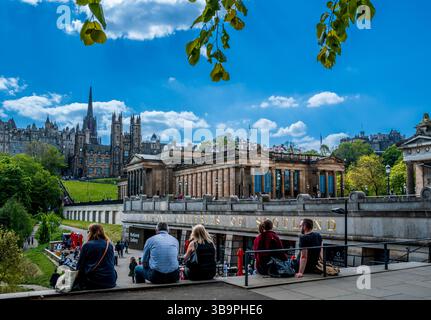 Menschen genießen die warme Frühlingssonne in den Princes Street Gardens in Edinburgh, Schottland Stockfoto