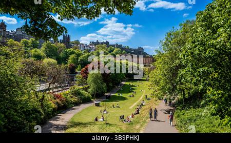 Menschen genießen die warme Frühlingssonne in den Princes Street Gardens in Edinburgh, Schottland Stockfoto