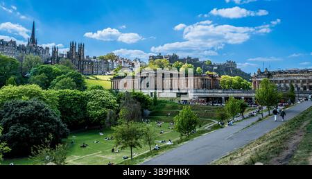 Menschen genießen die warme Frühlingssonne in den Princes Street Gardens in Edinburgh, Schottland Stockfoto