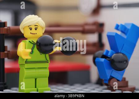 Tambow, Russische Föderation - 29. März 2025 Eine glückliche Lego-Frau Minifigur, die Gewichte in einem Fitnessstudio hebt. Stockfoto