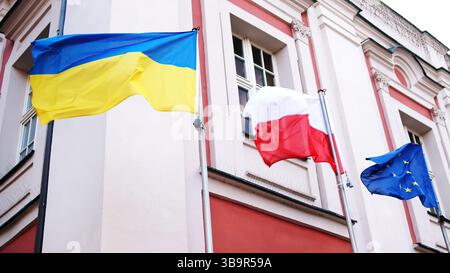 Schwenkende Flaggen Der Ukraine, Polens Und Der Eu Symbolisieren Das Vereinte Europa Stockfoto