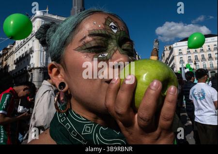 Madrid, Spanien. Mai 2025. Während des Global Marihuana Marsches wird eine Frau gesehen, die einen Joint durch einen Apfel raucht. Hunderte von Menschen marschieren durch das Stadtzentrum, um ein Gesetz zur Legalisierung von Cannabis zu fordern. Der Global Marihuana March findet jedes Jahr am Mai in vielen Städten der Welt statt. Quelle: Marcos del Mazo/Alamy Live News Stockfoto
