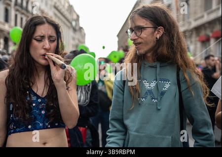 Madrid, Spanien. Mai 2025. Während des Global Marihuana Marsches wird eine Frau beim Rauchen eines großen Joint gesehen. Hunderte von Menschen marschieren durch das Stadtzentrum, um ein Gesetz zur Legalisierung von Cannabis zu fordern. Der Global Marihuana March findet jedes Jahr am Mai in vielen Städten der Welt statt. Quelle: Marcos del Mazo/Alamy Live News Stockfoto