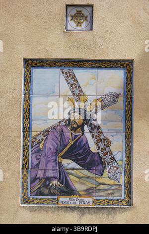 Keramikfliesen mit dem Kreuz Jesu Christi, „Nuestro Padre Jesus de las Penas“, ein Bild der Karwoche in Sevilla, Spanien. Stockfoto