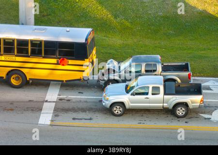 Verkehrsunfall auf der amerikanischen Straße in Florida. Ersthelfer helfen Opfern von Schulbus- und Autounfällen auf der Straße in den USA. Luftaufnahme des Notfalls Stockfoto