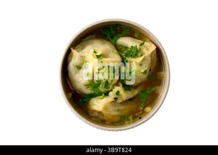 Manti (Manti oder Manty) in dicker Fleischsoße mit Kräutern in einer weißen Schüssel. Ein zentralasiatisches Gericht. Stockfoto