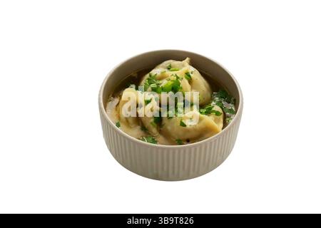 Manti (Manti oder Manty) in dicker Fleischsoße mit Kräutern in einer weißen Schüssel. Ein zentralasiatisches Gericht. Stockfoto