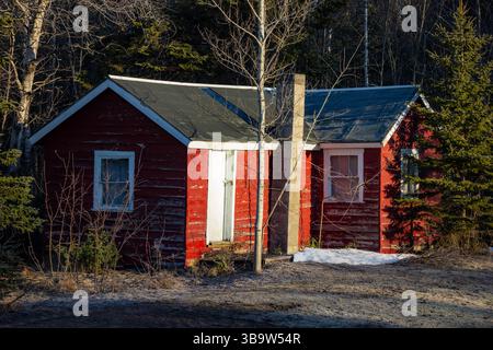 Picture Rocks, MI, USA - 27.04.2025: Foto einer kleinen roten Hütte umgeben von Waldbäumen, die rustikalen Charme, Einsamkeit und friedliche Waldlandschaft von setti zeigen Stockfoto
