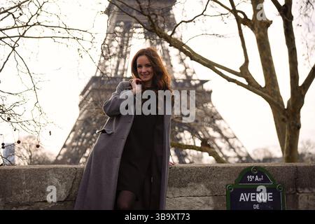 Frau, die vor dem Eiffelturm auf der Avenue de New York in Paris steht Stockfoto