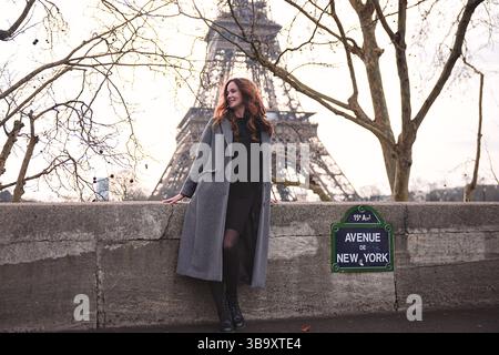 Frau, die in der Nähe des Eiffelturms auf der Avenue de New York in Paris steht Stockfoto