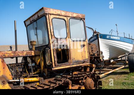 Weybourne, Norfolk, Vereinigtes Königreich – 10. Mai 2025. Rostiger Traktor schleppte früher Fischerboote wie die Anna Gail zum und vom Wasser am Weybourne Beach Stockfoto