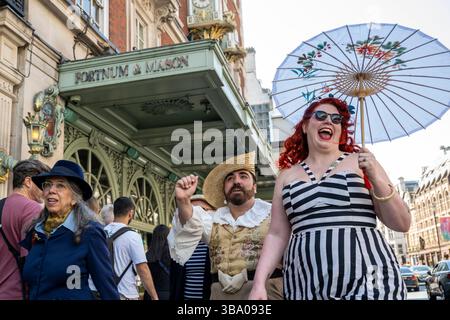 London, Großbritannien. 11. Mai 2025. Elegant gekleidete Personen nehmen am fünften Grand flâneur Walk Teil, vorbei am Kaufhaus Fortnum & Mason. Die Veranstaltung beginnt an der Beau Brummell-Statue in der Jermyn Street und ist definiert als ein Spaziergang ohne Zweck, der die Kunst der flâneur zelebriert, ohne etwas bestimmtes zu tun, und als Gegenmittel für die Anforderungen des modernen Lebens und des digitalen Smartphones. Quelle: Stephen Chung / Alamy Live News Stockfoto