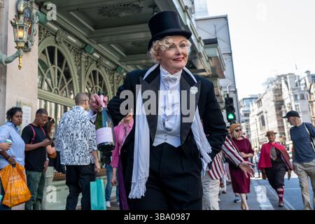London, Großbritannien. 11. Mai 2025. Elegant gekleidete Personen nehmen am fünften Grand flâneur Walk Teil, vorbei am Kaufhaus Fortnum & Mason. Die Veranstaltung beginnt an der Beau Brummell-Statue in der Jermyn Street und ist definiert als ein Spaziergang ohne Zweck, der die Kunst der flâneur zelebriert, ohne etwas bestimmtes zu tun, und als Gegenmittel für die Anforderungen des modernen Lebens und des digitalen Smartphones. Quelle: Stephen Chung / Alamy Live News Stockfoto