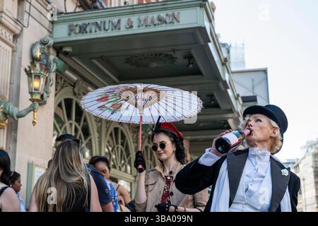 London, Großbritannien. 11. Mai 2025. Elegant gekleidete Personen nehmen am fünften Grand flâneur Walk Teil, vorbei am Kaufhaus Fortnum & Mason. Die Veranstaltung beginnt an der Beau Brummell-Statue in der Jermyn Street und ist definiert als ein Spaziergang ohne Zweck, der die Kunst der flâneur zelebriert, ohne etwas bestimmtes zu tun, und als Gegenmittel für die Anforderungen des modernen Lebens und des digitalen Smartphones. Quelle: Stephen Chung / Alamy Live News Stockfoto