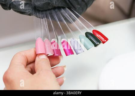 Bunte nagellackproben. Handauflage von Acrylfarben-Spitzen. Maniküre-Werkzeuge für Schönheitssalon. Glänzende, lebendige Nailart-Palette. Stockfoto
