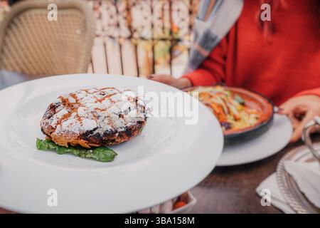 Nahaufnahme einer köstlichen Hühnchen pastilla, ein traditionelles marokkanisches Gericht, serviert auf einem weißen Teller Stockfoto