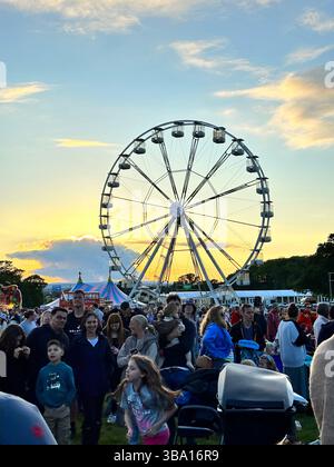 Das Riesenrad und das Festival kamen bei Sonnenuntergang während der Cheshire Balloon Fiesta am 6. August 2023 auf dem Bolesworth Estate, Tattenhall, UK. Stockfoto