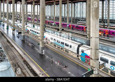 Madrid, Spanien - 10. März 2025: Blick von oben mit dem Bahnhof Atocha. Hochgeschwindigkeitszüge und Passagiere mit Gepäck Stockfoto