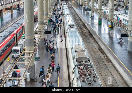 Madrid, Spanien - 10. März 2025: Geschäftiger Tag am Bahnsteig des Bahnhofs Atocha mit abfahrenden Fahrgästen und modernen Hochgeschwindigkeitszügen. Stockfoto