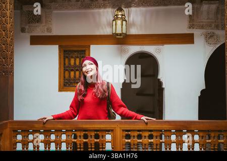 Junge Frau erkundet das traditionelle marokkanische Riad und genießt die komplizierten Details und das kunstvolle Design Stockfoto