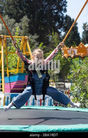 Das Mädchen hat Angst, auf das Trampolin zu springen Stockfoto