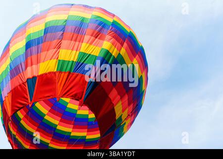 Farbenfroher Heißluftballon, der auf dem Festival gegen den blauen Himmel schwimmt Stockfoto