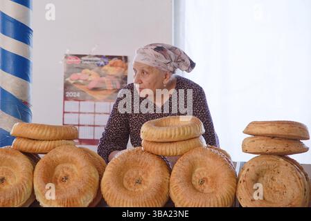 Usbekischer Brotverkäufer mit Kopftuch auf dem Chorsu-Basar in Taschkent in Usbekistan Stockfoto