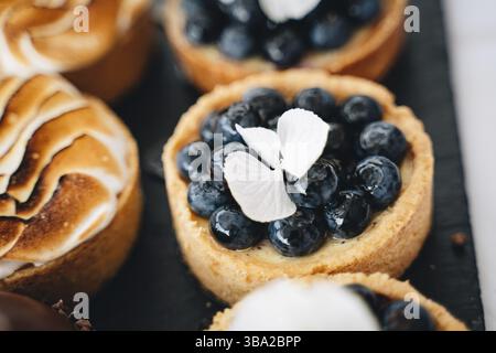 Foto von vielen köstlichen Blaubeeren kleinen Törtchen Stockfoto