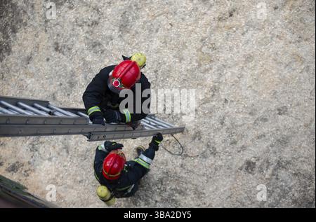 Feuerwehrmann steigt die Treppe hoch. Rettungsschwimmer-Training Stockfoto