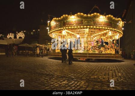 London, Großbritannien, 25. November 2006: Menschen zu Fuß herum und beobachten Karussell in Abend in Covent Garden, das beliebte tou beleuchtet Stockfoto