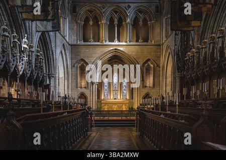 Dublin, Irland, August 2019 wunderschön beleuchteter Hauptaltar in der St. Patricks Cathedral mit gotischen Bögen und Buntglas, Europa Stockfoto