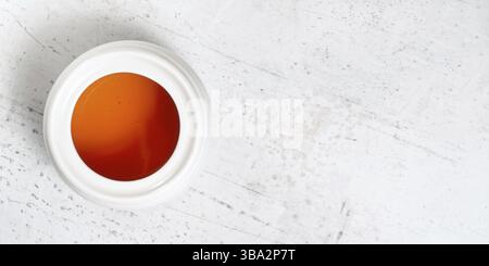Weißes Porzellanglas mit Honig auf weißem Steinbrett, Foto von oben, breites Banner mit Platz für Text rechts, Liptovsky Hradok, Slowakei, Europa Stockfoto