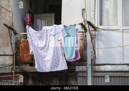 Die Wäsche hängt auf einem alten schäbigen Balkon zum Trocknen Stockfoto