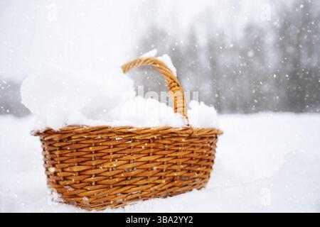 Mit Schnee gefüllter Korb auf weihnachtlichem Hintergrund. Schnee in einem Korb Stockfoto
