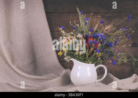 Wildblumen in weißer Keramik Krug und Tassen auf Tablett Stockfoto