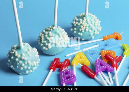 Kuchen mit regenbogenfarbenen Geburtstagskerzen mit der Aufschrift Happy Birthday. Jubiläumsfeier Stockfoto